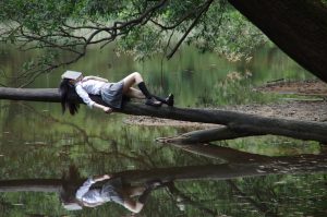 Girl dreaming on tree with a book on her head