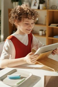 Happy girl learning on her tablet