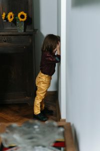 Child crying against a door